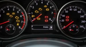 Car dashboard showing empty fuel gauge and warning lights