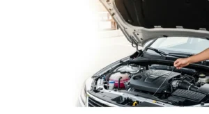 Person checking engine oil under open car hood in a clean modern engine bay