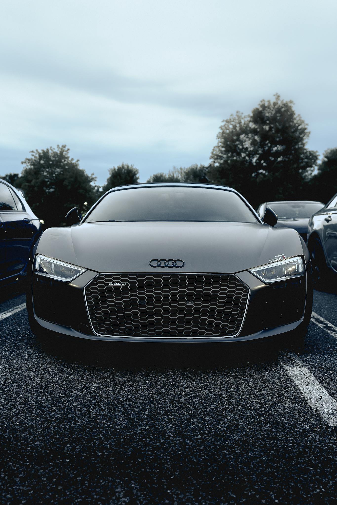 A modern Audi R8 car is prominently displayed in an outdoor parking lot, showcasing its sleek design.