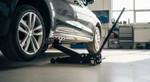 Hydraulic floor jack lifting a car safely inside a garage