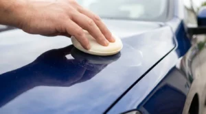 applying wax to protect car exterior paint