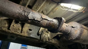 repairing car exhaust leak in auto repair shop
